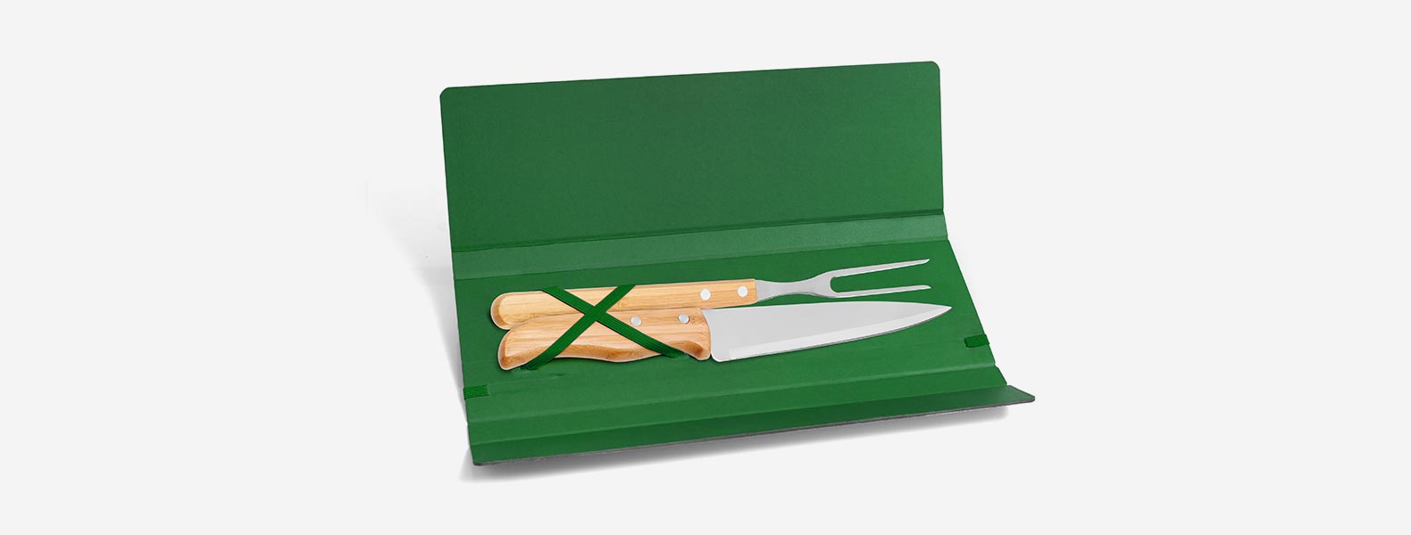 Conjunto composto por uma faca 7” e um garfo trinchante, ambos com cabos em Bambu e lâminas em Aço Inox com rebites resistentes. Estão organizados em uma pasta verde com elásticos.